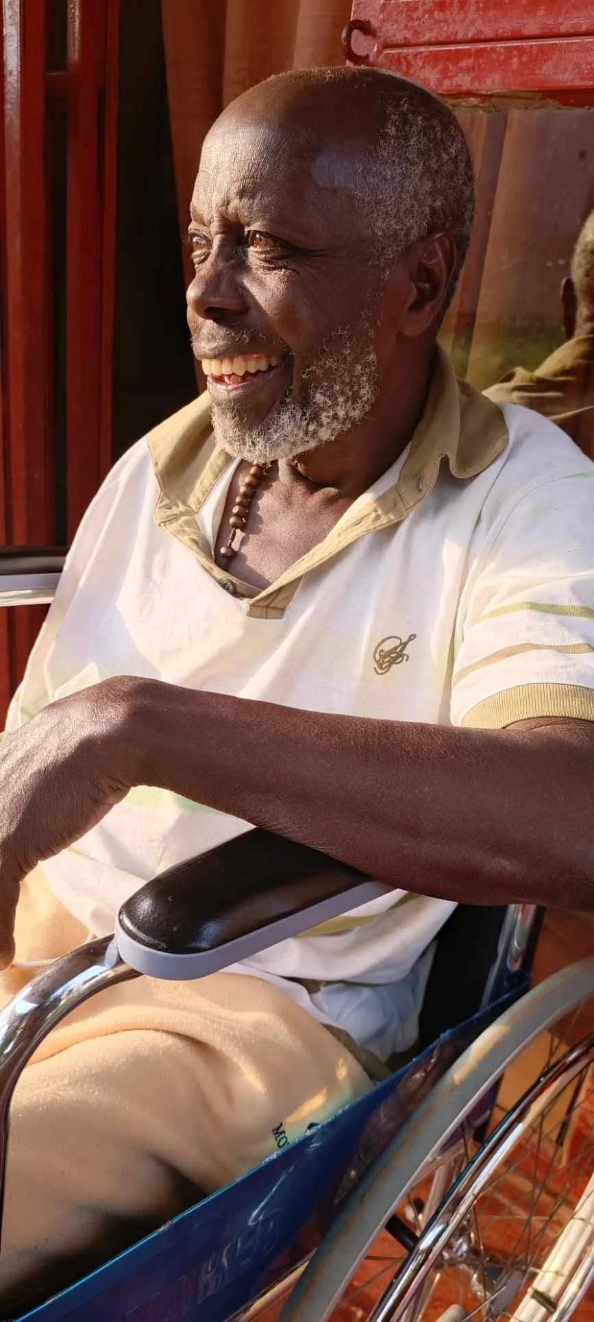 Edward Mpagi Edmary smiling while seated outdoors