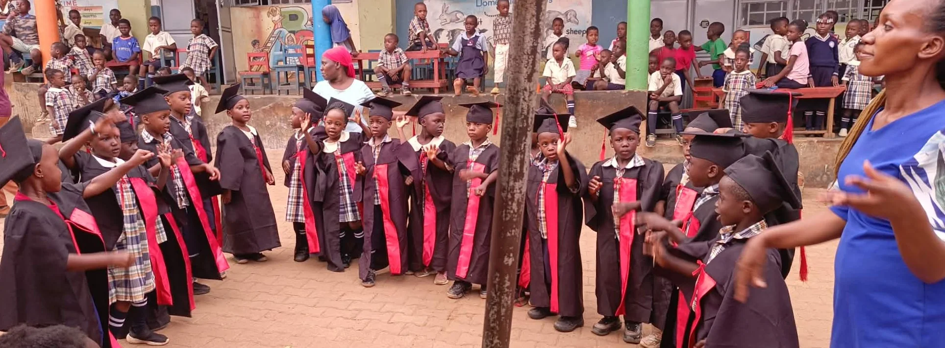 Young graduates in caps and gowns gathered with classmates in the courtyard
